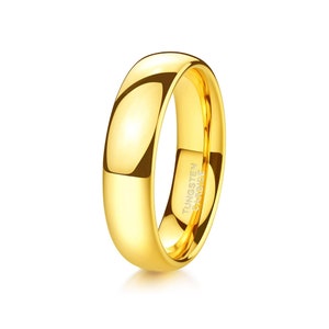 May include: A gold tungsten carbide ring with a polished finish. The ring has a beveled edge and is engraved with "TUNGSTEN CARBIDE".