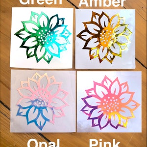 May include: Four sunflower decals on white backgrounds. The decals are iridescent and come in the colors green, amber, opal, and pink.