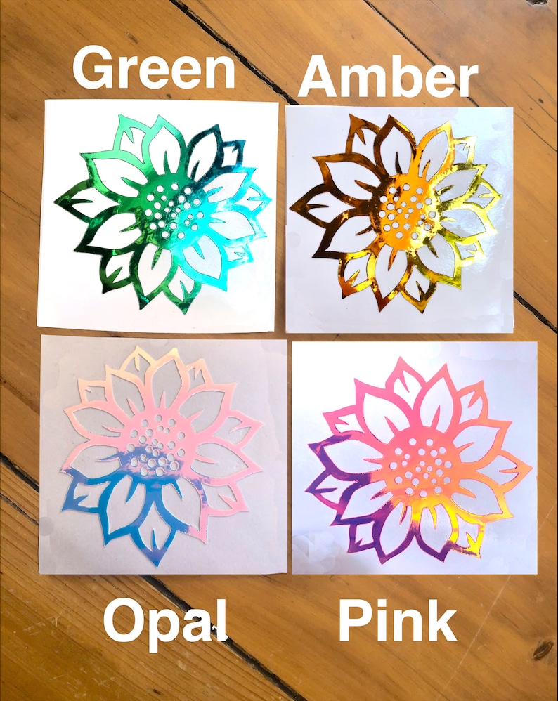 May include: Four sunflower decals on white backgrounds. The decals are iridescent and come in the colors green, amber, opal, and pink.