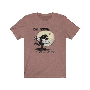 May include: A heather grey t-shirt with a vintage-style graphic of a bear surfing with the text "CALIFORNIA DREAMING" and a red star.