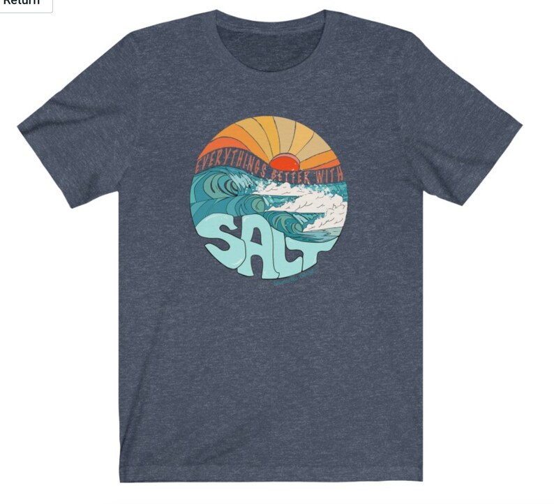 Puede incluir: Una camiseta azul con un gr&aacute;fico retro de una puesta de sol sobre olas oce&aacute;nicas. El gr&aacute;fico dice "Everything's Better With Salt".