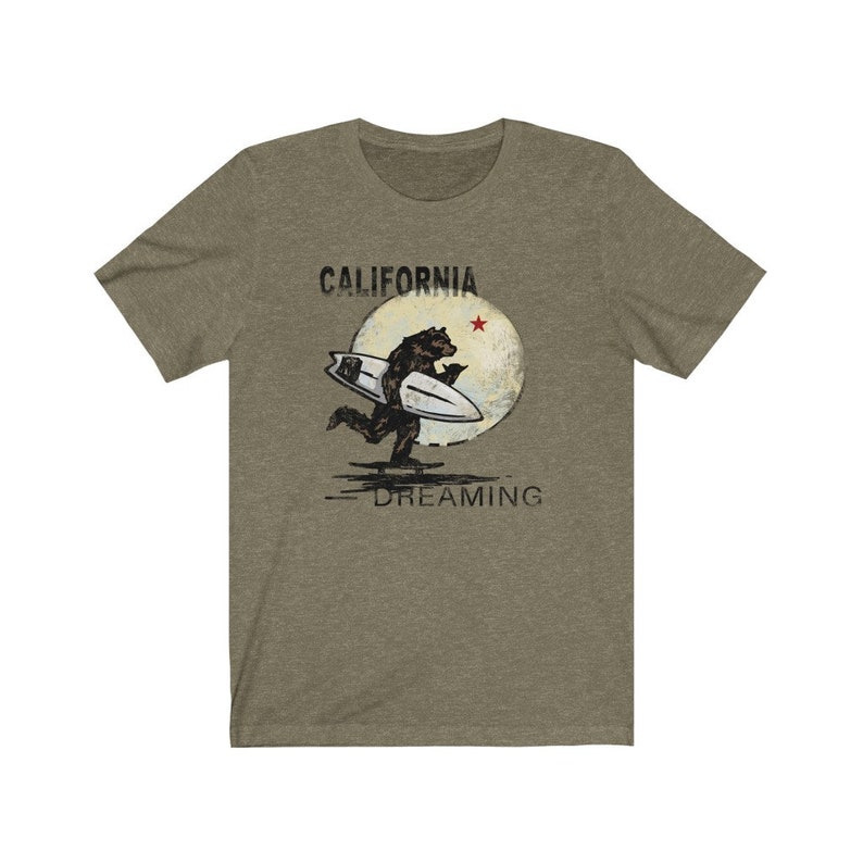 May include: A green t-shirt with a graphic of a bear surfing on a wave with a moon and a red star in the background. The text "CALIFORNIA DREAMING" is printed below the graphic.
