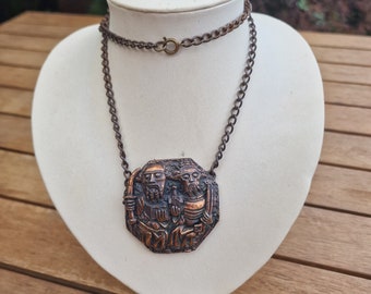 Stary wisiorek z wizerunkiem świętych Piotra i Pawła, na łańcuszku.