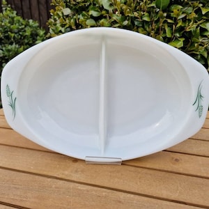 Könnte beinhalten: Weiße, geteilte Servierplatte mit grünem Weizenmuster. Die Platte ist oval und hat zwei Abschnitte.