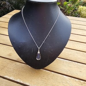 Pretty necklace with  grey clear glass pendant on silver tone chain.
