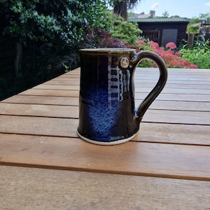 One vintage stoneware coffee cup or mug in lovely dark blue colour.