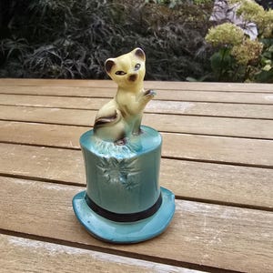 Vintage keramisk klockfigur av en siamesisk katt på en grön hög hatt, 1960-70-talet.
