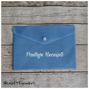 May include: A light blue envelope with a flap closure and a white button. The text "Postage Receipts" is written in white script across the front. The bottom left corner has the text "@craftformers".