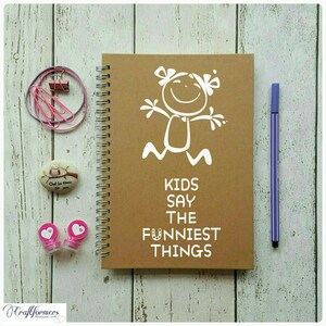 May include: A brown spiral bound notebook with a white stick figure drawing and the text "Kids Say The Funniest Things".