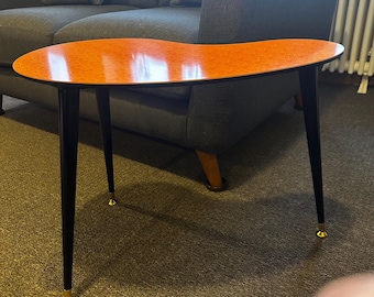 Mesa auxiliar para plantas con forma de riñón, estilo mediados de siglo, para colocar junto al sofá o al pie de la misma. Fabricada en laminado Royalexe en 12 colores.