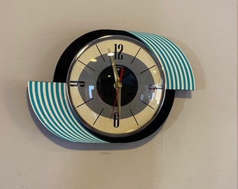 Horloge murale de cuisine en forme d'œil gravé aux couleurs de Kandy de Royale - Style rétro Atomic Jetsons du milieu du siècle en turquoise et crème.