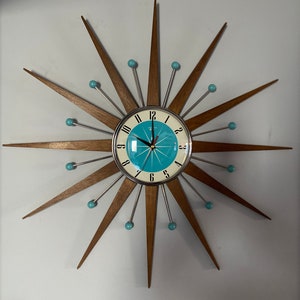 Reloj de pared Starburst más vendido de Royale Mid Century Estilo moderno Cromo Silencioso Medio Rayos de teca Cara turquesa Bolas atómicas Fabricación británica