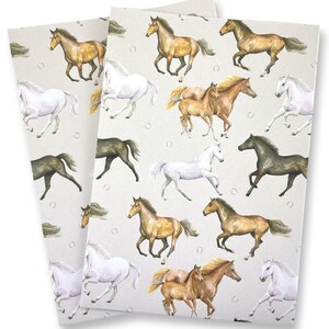 May include: Two sheets of paper with a repeating pattern of running horses in various colors, including white, brown, and black. The horses are depicted in a watercolor style against a light beige background with horseshoe accents.