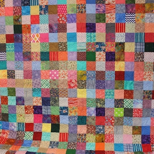 May include: A colorful patchwork quilt with a variety of fabrics and patterns. The quilt is made up of many small squares, each with a different design. The quilt is a vibrant mix of colors, including red, blue, green, yellow, and purple.