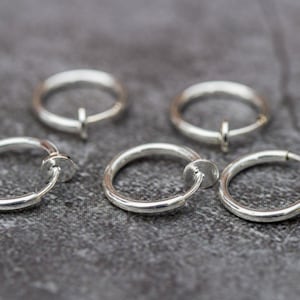 Puede incluir: Cuatro pendientes de aro de plata sin perforar. Los pendientes están diseñados para sujetarse al lóbulo de la oreja.