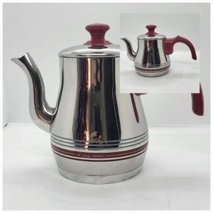 May include: A silver stainless steel teapot with a red lid and handle. The teapot has a silver and red striped design and the text "All-Value 0000" on the bottom.
