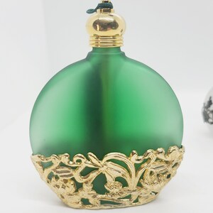 Green glass with gold tone metal filigree detail bottle.