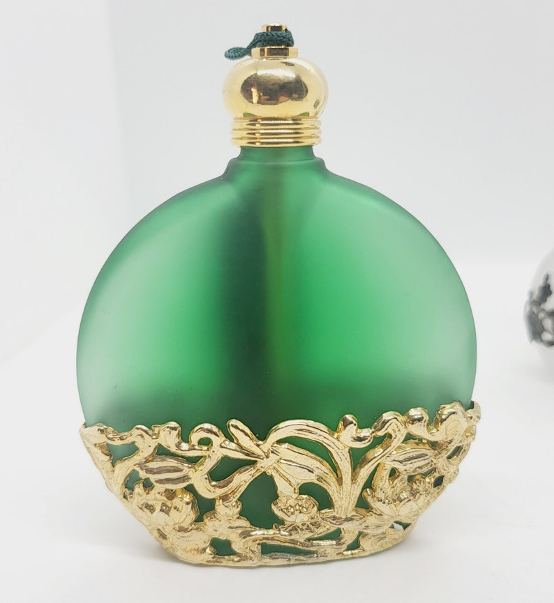 Green glass with gold tone metal filigree detail bottle.
