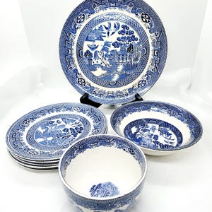 May include: A set of blue and white willow pattern dinnerware, including a large dinner plate, a set of smaller plates, a soup bowl, and a smaller bowl.