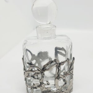 clear glass with silver tone metal filigree detail.
