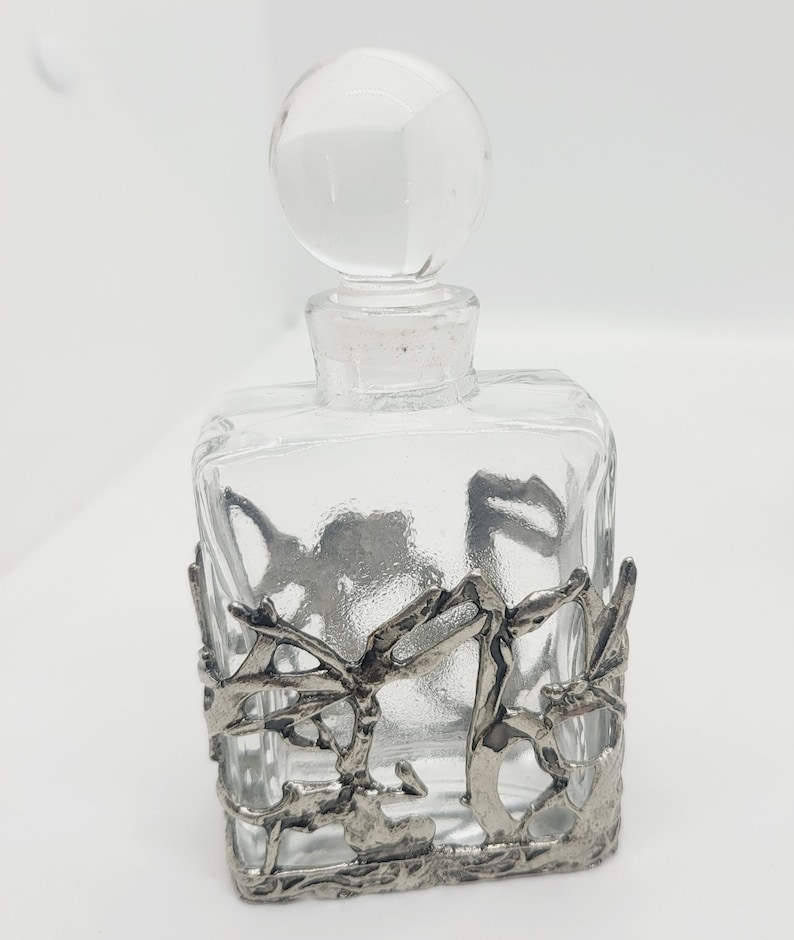 clear glass with silver tone metal filigree detail.