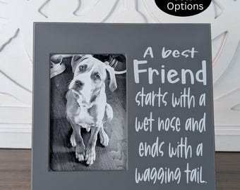 May include: Gray picture frame with a white border and a black and white photo of a dog inside. The frame has the text "A best Friend starts with a wet nose and ends with a wagging tail." printed on it.