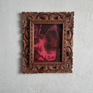 May include: A rectangular painting featuring abstract layers of deep crimson, magenta, and black paint. The artwork is encased in a thick, dark brown wooden frame with intricate, carved floral and leaf patterns along the outer border.