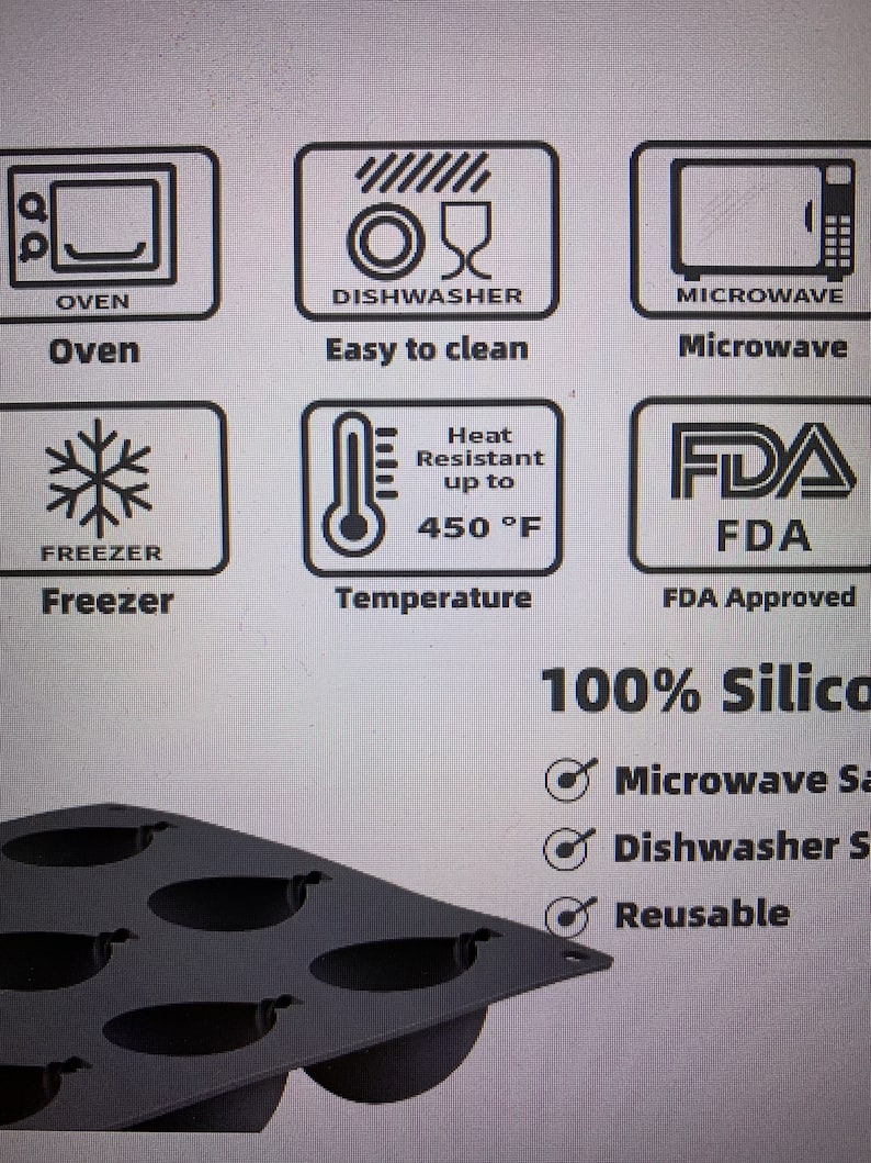 May include: A dark gray silicone baking mold with multiple oval-shaped cavities. The image includes icons indicating the mold is oven, microwave, and freezer safe, easy to clean, and heat resistant up to 450&deg;F. The text states it is 100% silicone.