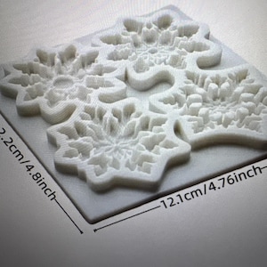 Può includere: Uno stampo in silicone bianco con tre disegni di fiocchi di neve. Lo stampo misura 12,1 cm di larghezza e 12,2 cm di lunghezza. I fiocchi di neve presentano dettagli intricati, perfetti per progetti di artigianato o pasticceria.