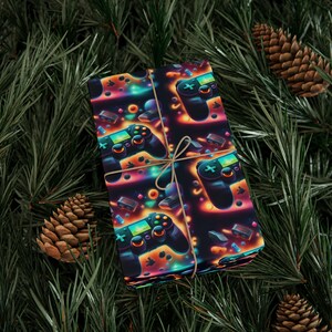May include: A black and neon-colored wrapping paper with a repeating pattern of video game controllers, stars, and other gaming-themed elements. The paper is wrapped around a gift box and tied with twine.