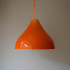 May include: Orange pendant light with a rounded, bell-shaped shade.