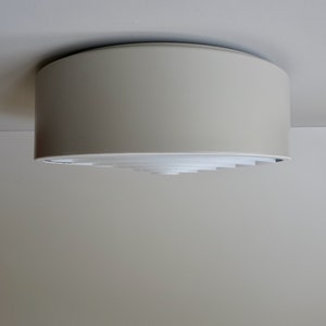 Peut inclure: Luminaire de plafond blanc avec un design circulaire et un motif géométrique en couches.