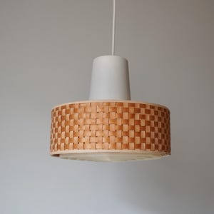 May include: A white and brown woven pendant light fixture with a white cord.