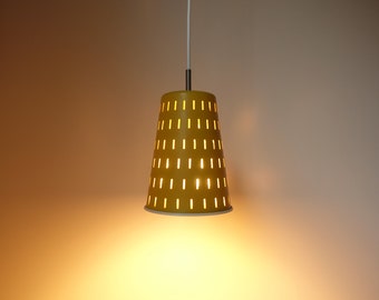 May include: A yellow pendant light with a cone-shaped shade featuring a pattern of vertical slits. The light is on and illuminating the room.