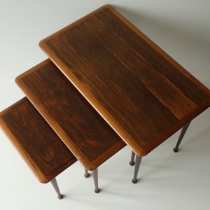 Complete set of three hard exotic rosewood wooden 1960s nesting side tables stackable mid century modern tapered legs