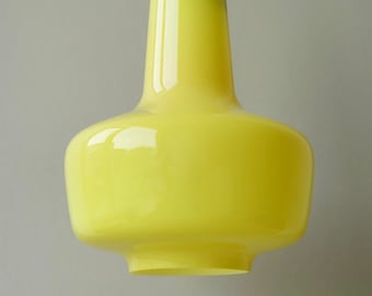 May include: A yellow glass pendant light fixture with a rounded, bulbous shape.