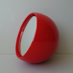 Op de afbeelding: Een ronde, handzame spiegel in felrood met een zilveren frame. De spiegel is schuin geplaatst.