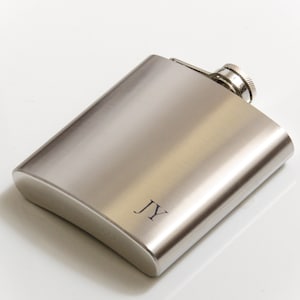 May include: A silver hip flask with a screw-on cap and the initials "JY" engraved on the front.