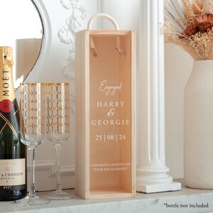 May include: A wooden box with a rope handle, personalised with the text "Engaged Harry & Georgie 25|08|24 Congratulations on your engagement".