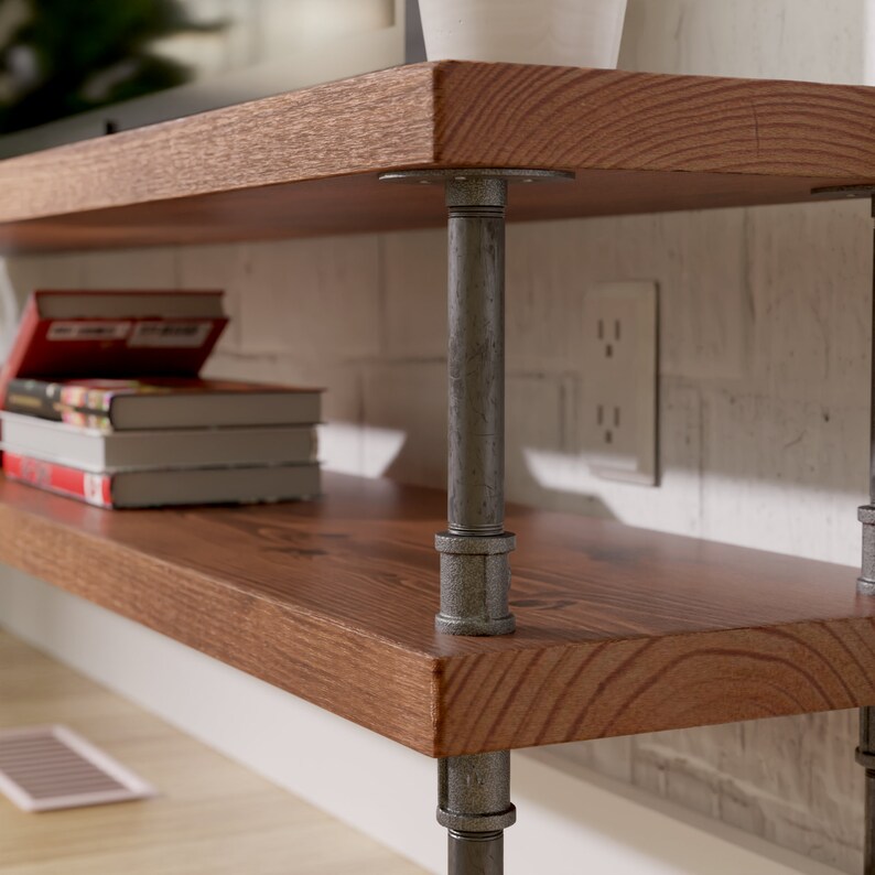 Puede incluir: Dos estantes de madera sostenidos por patas de tuber&iacute;a industrial. Los estantes son de madera marr&oacute;n oscura con un patr&oacute;n de veta natural. Las tuber&iacute;as est&aacute;n pintadas de color gris oscuro. Los estantes est&aacute;n montados en una pared de ladrillo blanco.