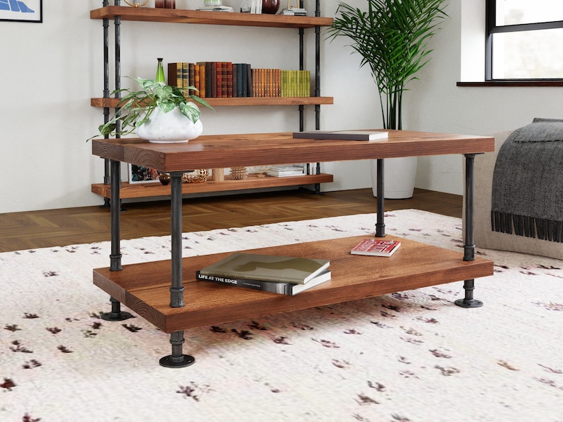 May include: A two-tiered coffee table with a rustic wood top and black metal pipe legs. The table is sitting on a white rug with a black and white pattern.