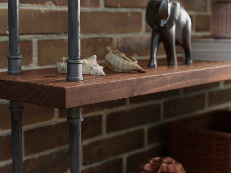 May include: A dark brown wooden shelf with black metal pipe supports. The shelf is decorated with seashells and a black elephant figurine.