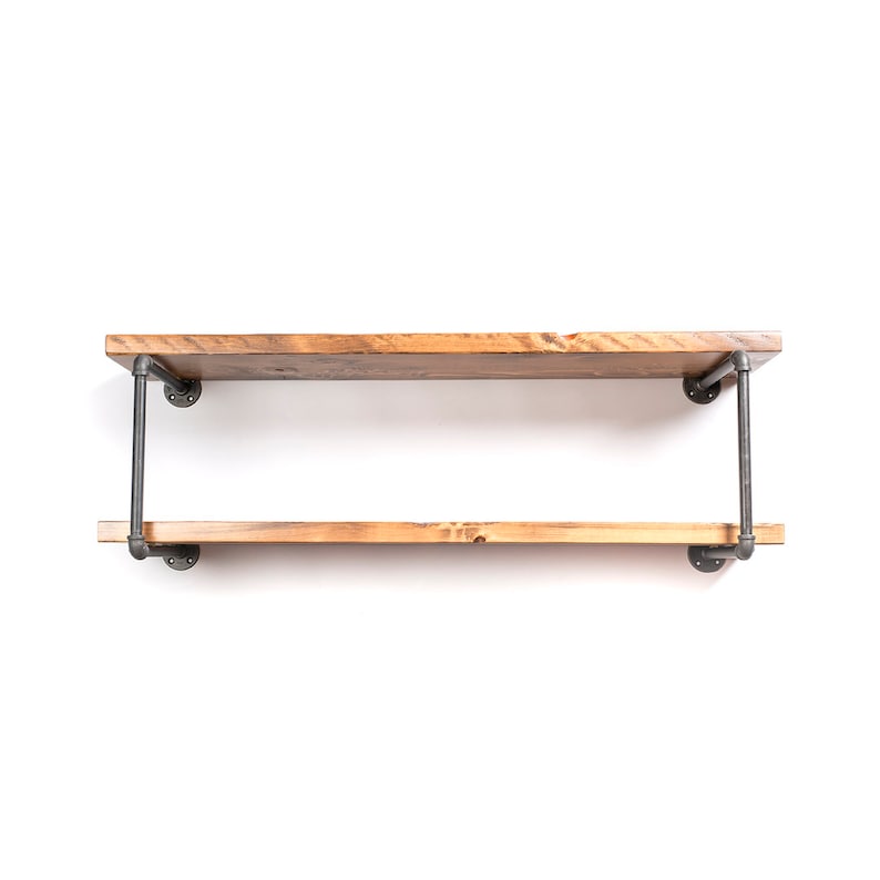 May include: Two-tiered wooden shelf with black metal pipe supports. The shelf is made of reclaimed wood and has a rustic finish.