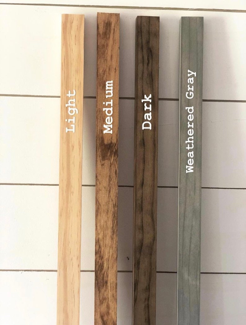 May include: Four wood samples in different shades of brown and gray. The samples are labeled "Light", "Medium", "Dark", and "Weathered Gray".