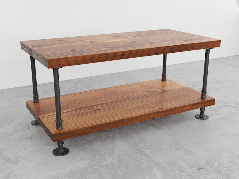 May include: A two-tiered coffee table with a rustic wooden top and black metal pipe legs. The table has a natural wood finish and is supported by four legs.