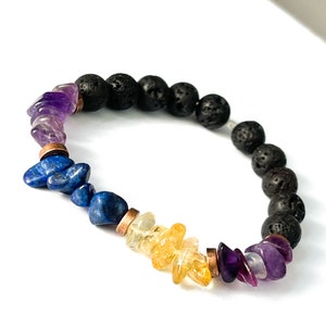 May include: A beaded bracelet with black lava rock beads, amethyst, lapis lazuli, and citrine stones. The bracelet has copper spacers between the stones.