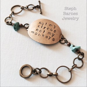 May include: A brass bracelet with a charm that reads "not my circus not my monkeys". The bracelet also features turquoise and brown beads.