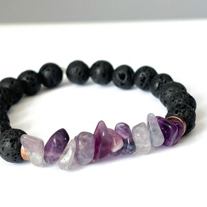 May include: A black lava rock bracelet with a row of purple amethyst chips.