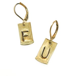 May include: A pair of gold-toned earrings with lever-back closures. Each earring features a rectangular charm with the letters "F" and "U" stamped into the metal. The earrings are displayed against a white background.