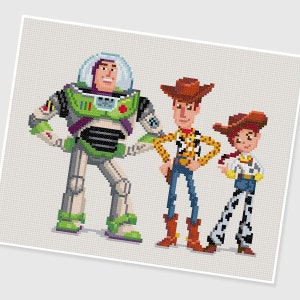 Può includere: Un'illustrazione pixelata di Buzz Lightyear, Woody e Jessie del franchise Toy Story. Buzz Lightyear è un ranger spaziale verde e bianco con una placca toracica viola. Woody è un cowboy con un cappello marrone, una camicia gialla e jeans blu. Jessie è una cowgirl con un cappello rosso, una camicia gialla e jeans blu con stampa di mucca bianca e nera.